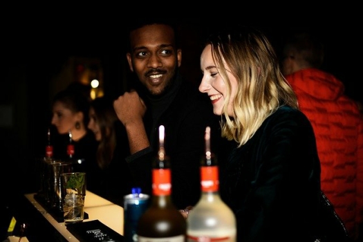 Image of a white young woman and a young black man at a bar